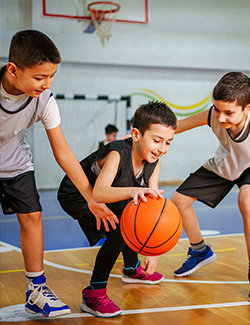Three children playing basketball.