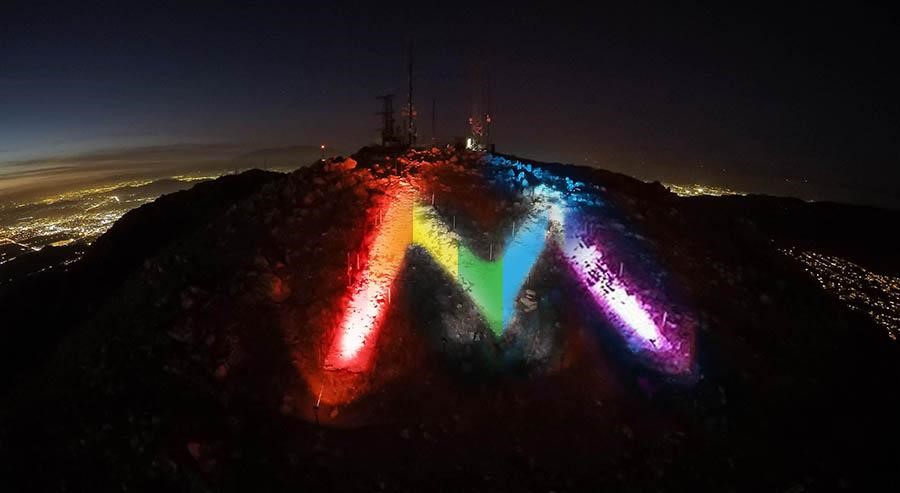 The M lit in rainbow colors.
